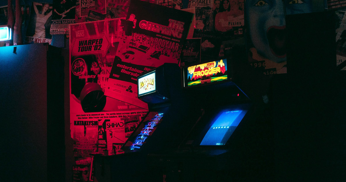 Игровые автоматы в компьютерном клубе, стоящие в красноватом полумраке