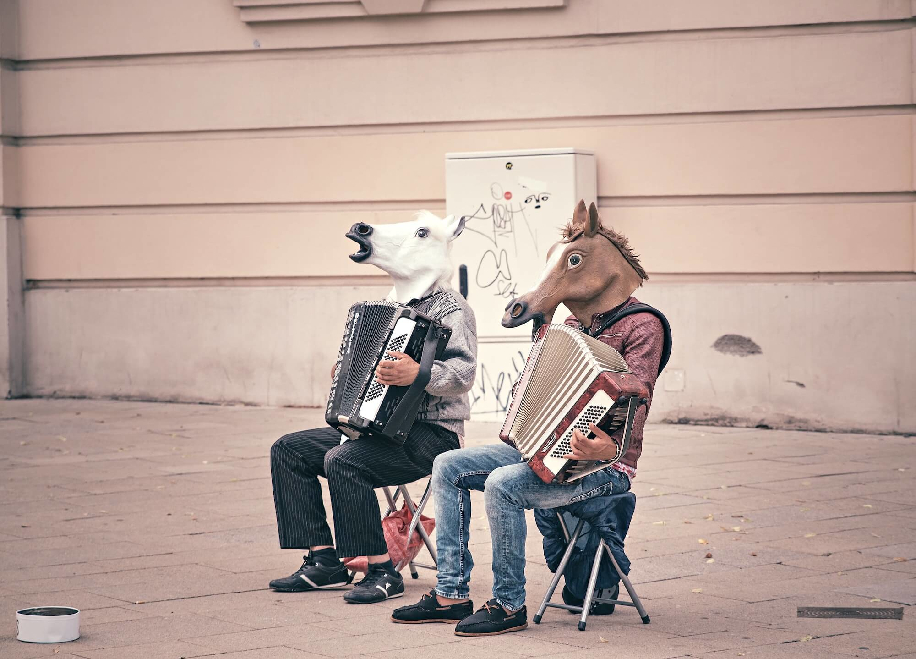 Мужчины в лошадиных масках играют на аккордеонах на улице