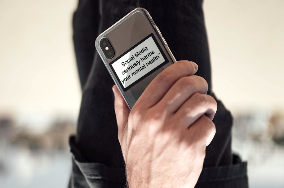 Предупреждающая напдпись на смартфоне о вреде социальных медиа, выполненная по аналогии с пачкой сигарет