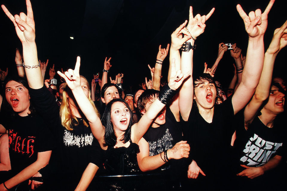 Фанаты рок-музыки на концерте в танцевальном партере